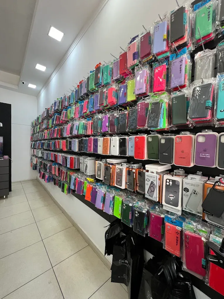 Parede da loja Conecta cheia de capas de celular de várias cores